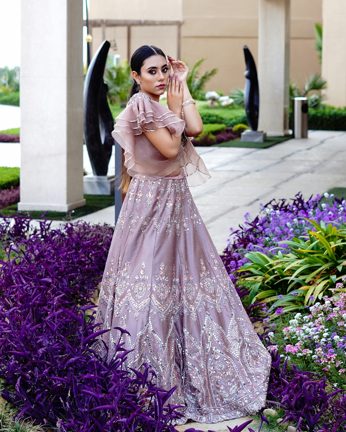 a woman in a long dress standing in a garden