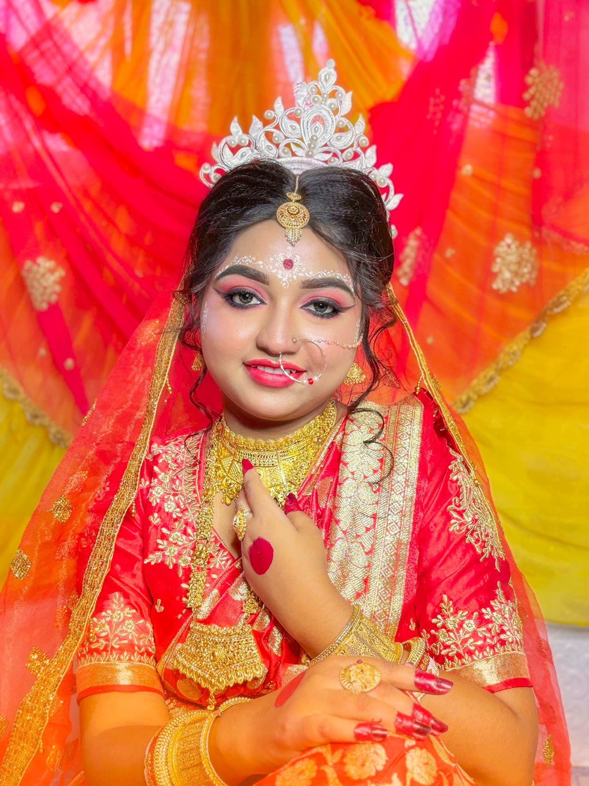 A woman is in traditional indian bridal attire.
