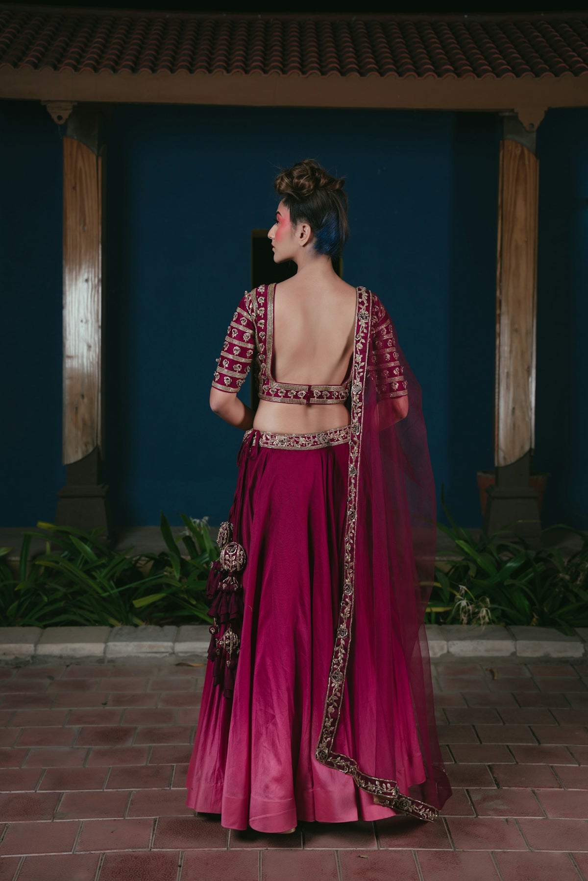 Woman in ornate magenta lehenga with blue hair
