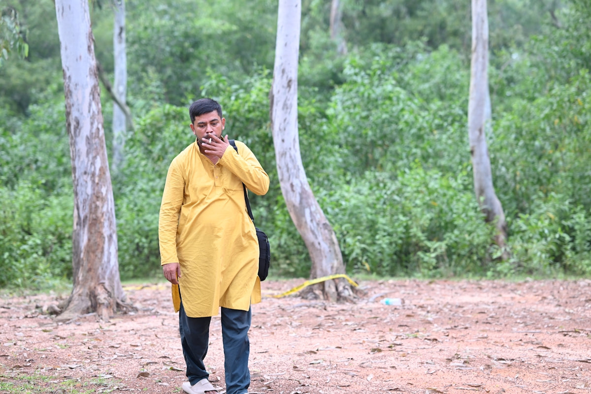 Man in yellow kurta walking in a forest