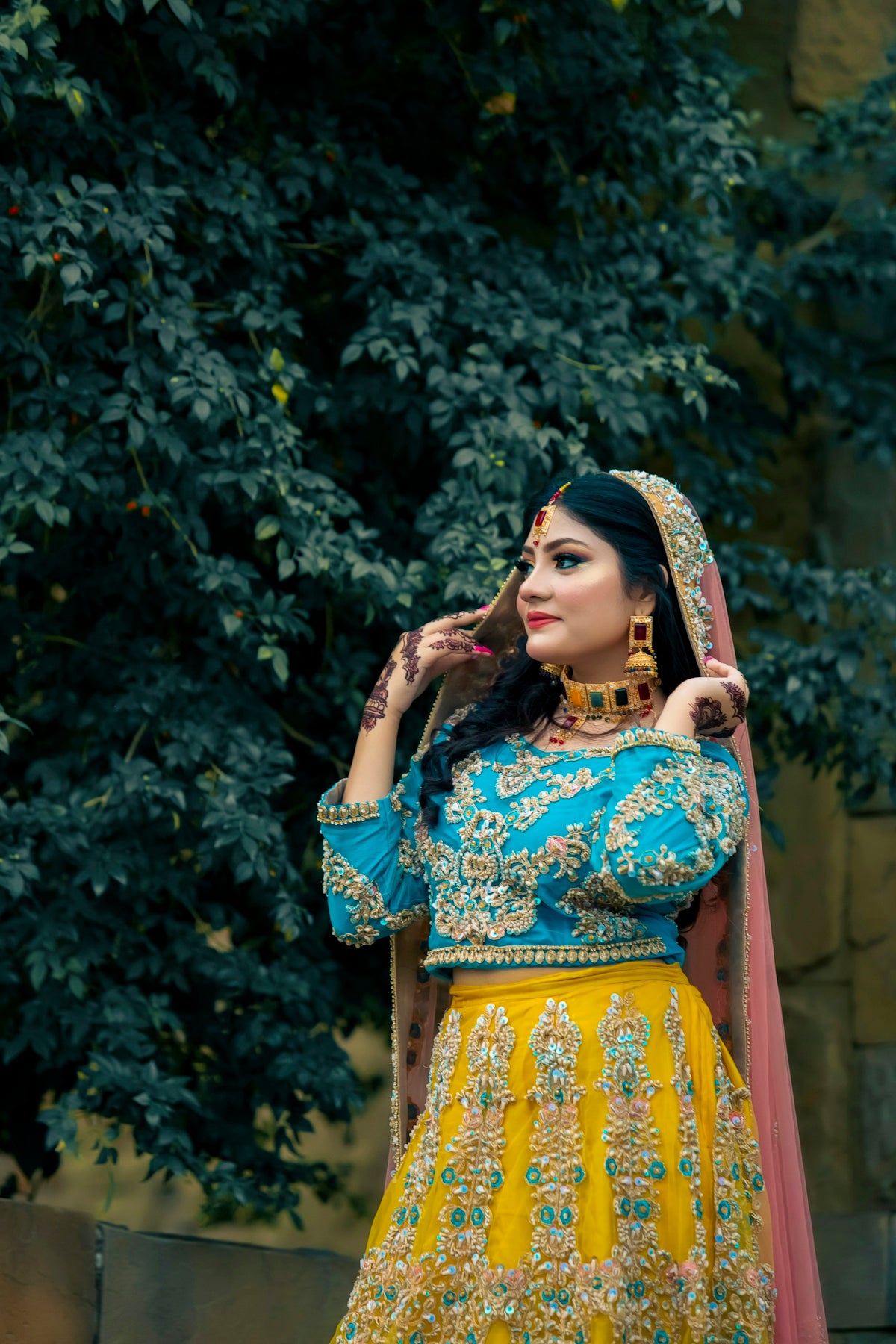 A woman in traditional indian attire poses outdoors.