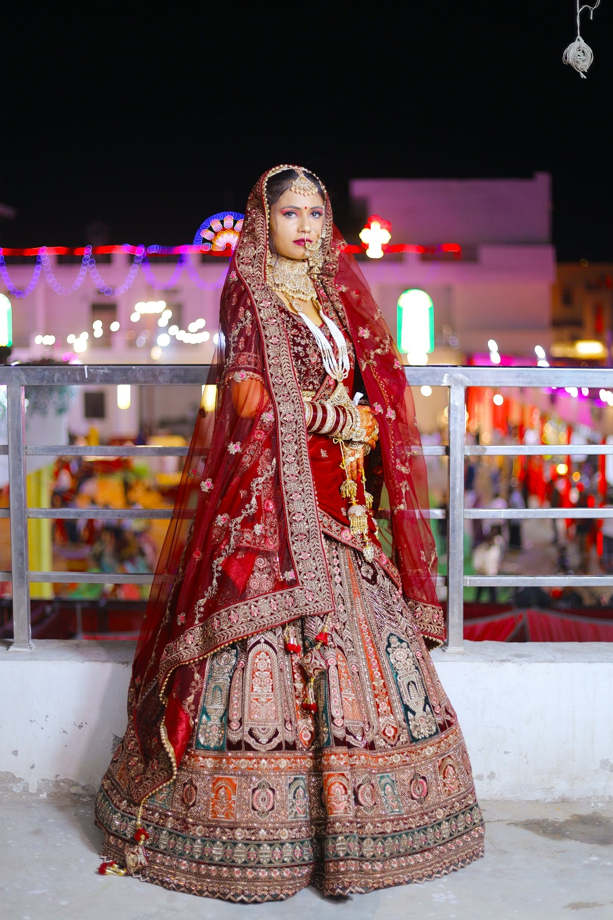 A bride in a traditional red lehenga and veil.