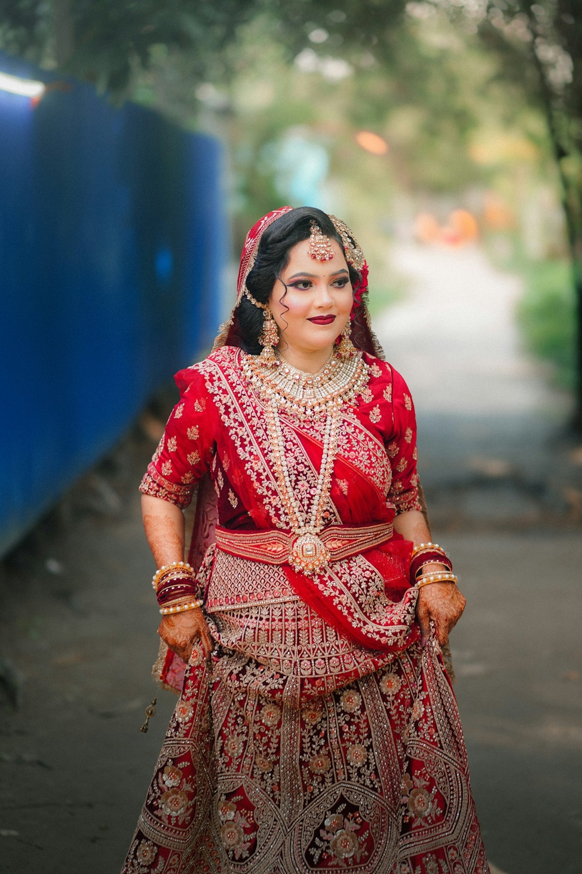 A bride in a red and gold ornate lehenga