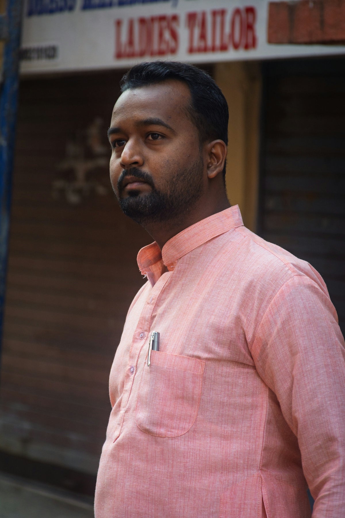 Man in pink kurta with pen in pocket
