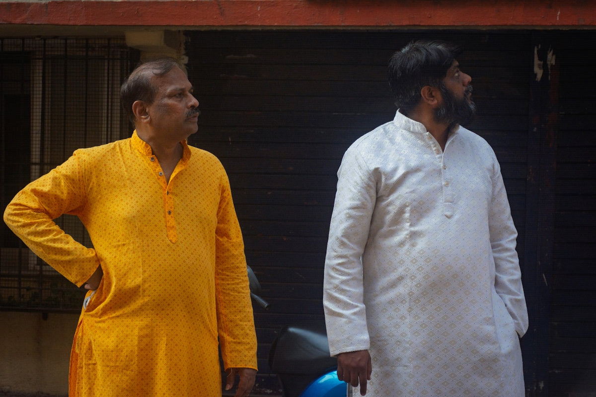Two men in traditional indian clothing looking away.
