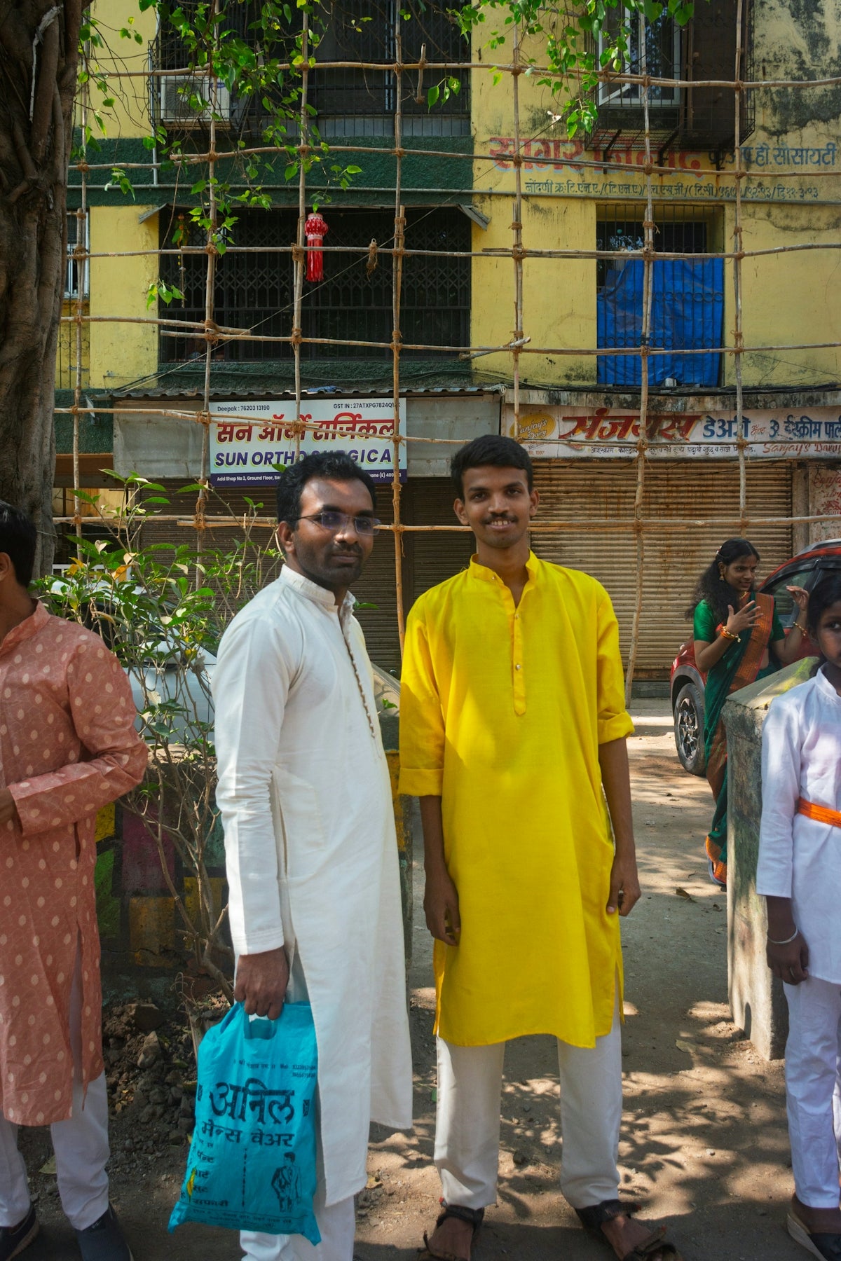 Two men in traditional indian clothing stand outside.