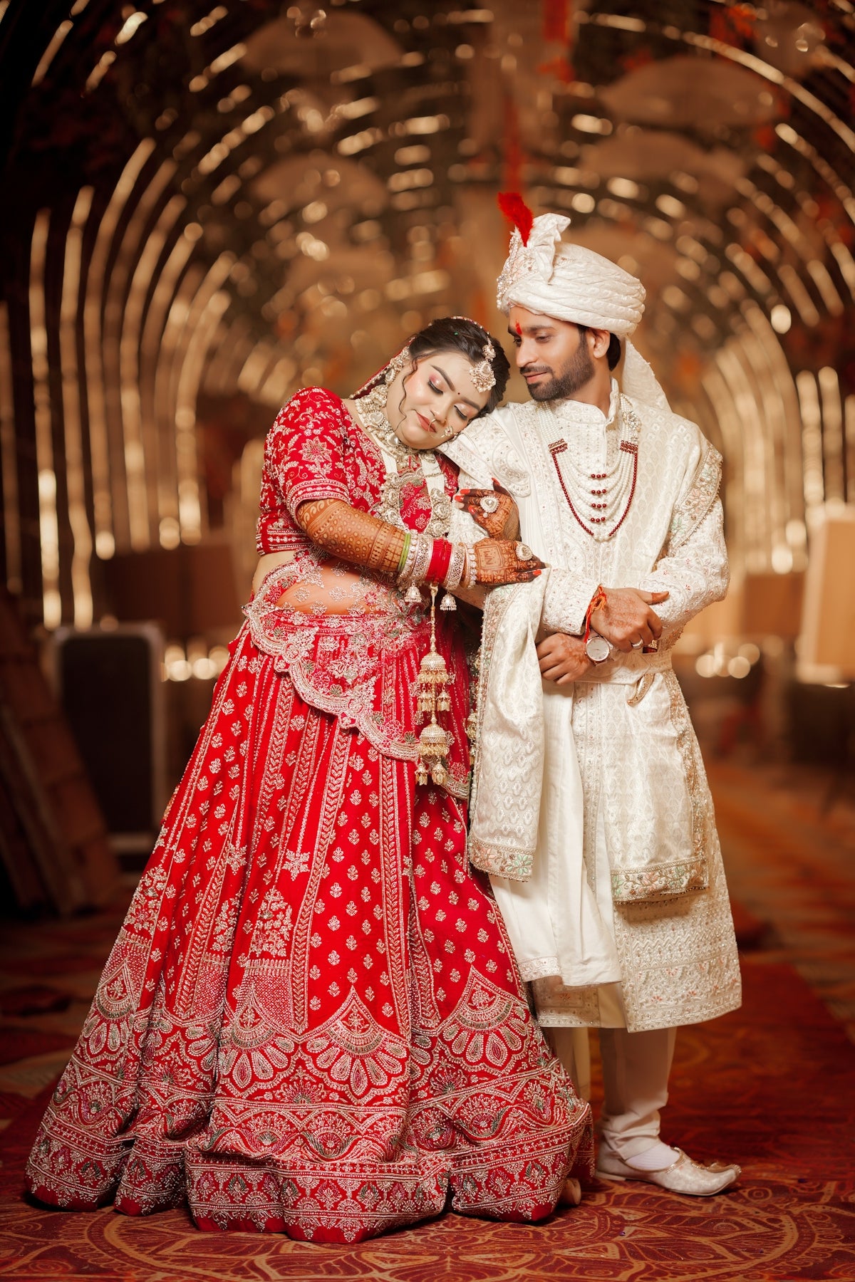 Elegant indian wedding couple in traditional attire posing together.