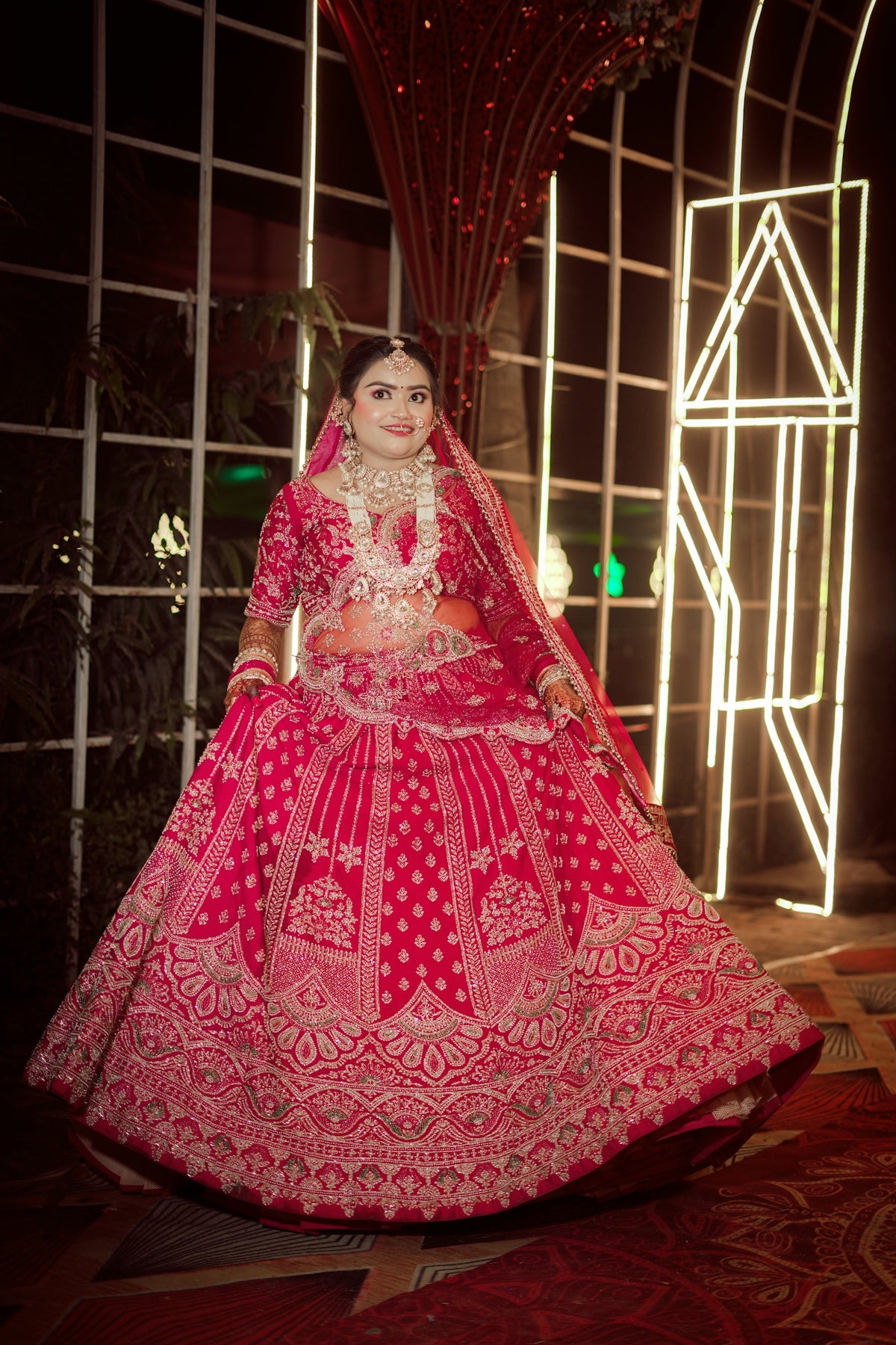 A beautiful indian bride in a traditional red lehenga.