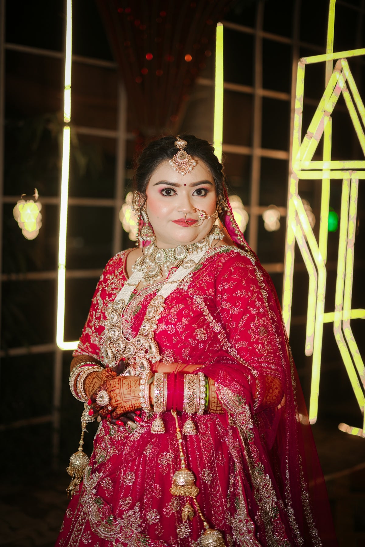 A beautiful indian bride in traditional red attire and jewelry.