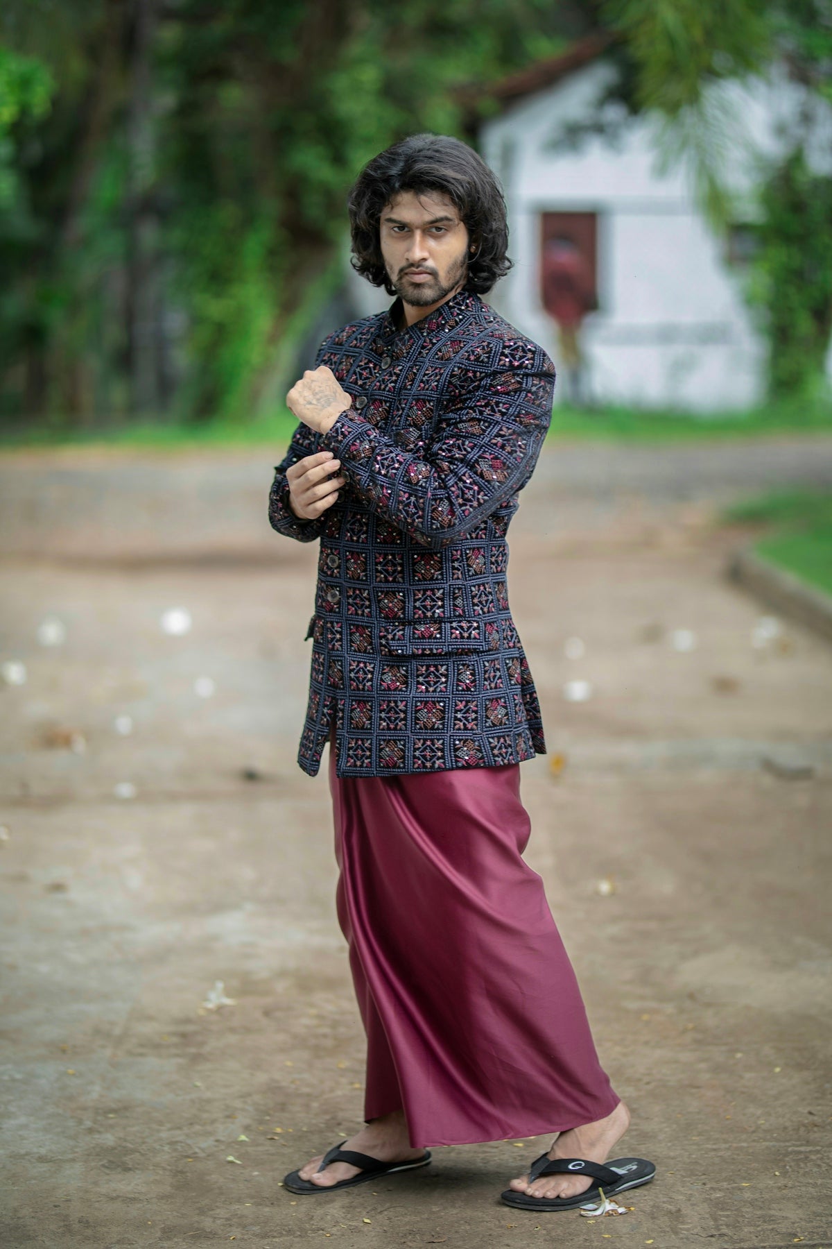 Stylish man in traditional attire adjusts his jacket cuff